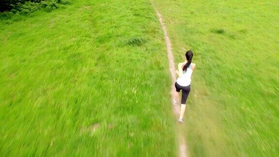 健康的女人在绿色的风景中奔跑