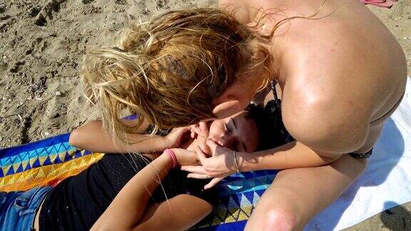 暑假期间青少年在海滩上清理脸上的痘痘