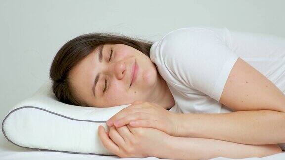 一个女人躺在她最喜欢的整形枕头和床垫上健康的睡眠