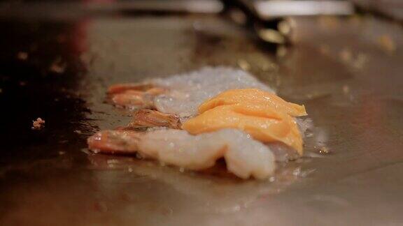 近距离观看日本厨师在烤炉上烹饪虾铁板烧与海鲜虾在热板上炸慢动作
