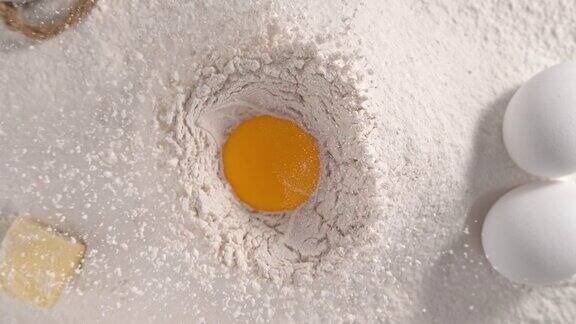 在慢镜头中生蛋黄落入面粉堆中-俯视视图