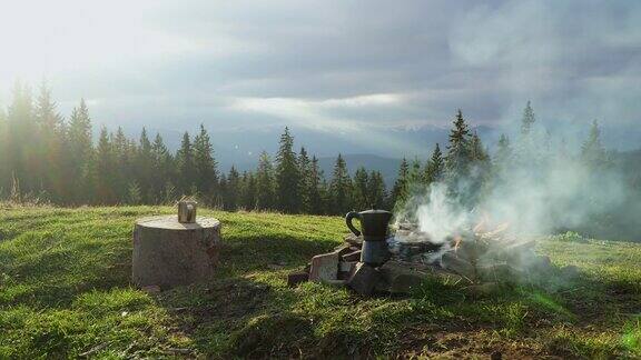 咖啡杯和咖啡壶在山中的火堆旁