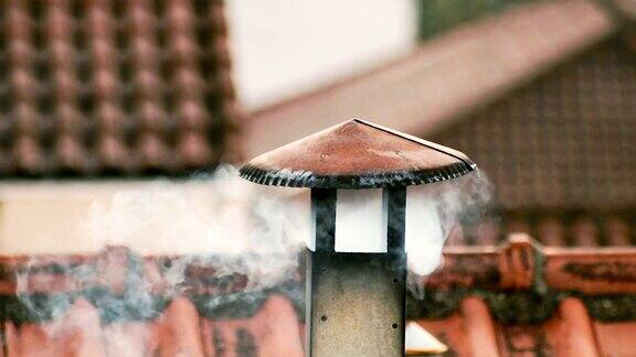 烟从房子的烟囱里冒出来屋顶上的管子烟囱中国的房子有烟囱的房子屋顶上的烟