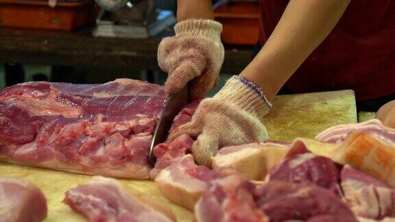 慢动作猪肉店老板用刀在木板上切生肉