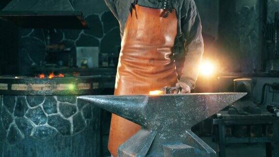 一个人在铁匠铺的铁砧上用刀干活