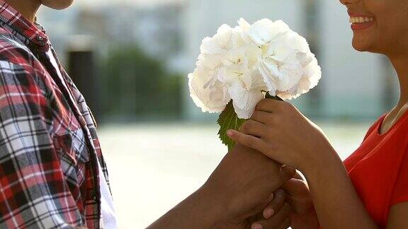 十几岁的男孩送给女友一束鲜花邀请她进行浪漫的约会