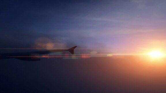黄昏时从窗口看飞机机翼和天空