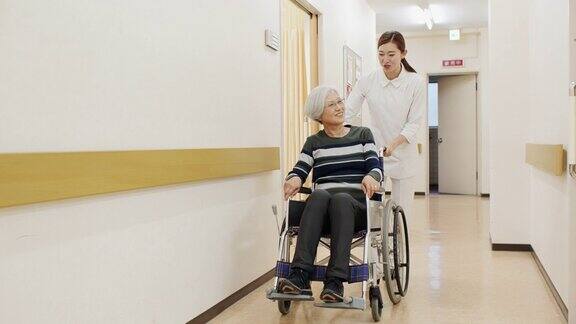 护士用轮椅推病人走过医院走廊