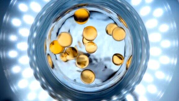 在装有水的玻璃烧杯里落下一粒透明的黄色胶囊药