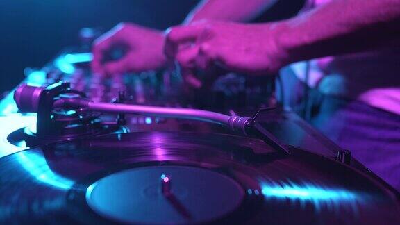 转盘播放黑胶唱片与音乐的电子派对在夜总会DJ在舞台上播放专注于唱盘针和调音臂