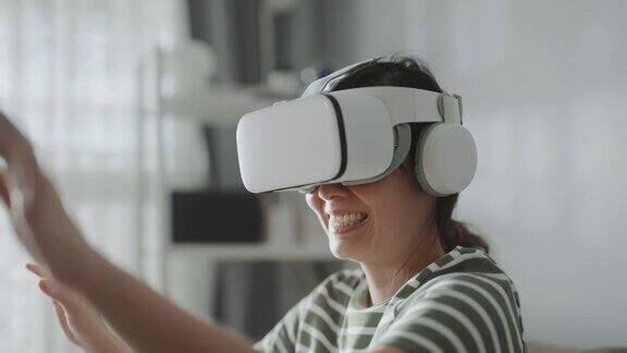 亚洲女人在家里使用虚拟现实眼镜