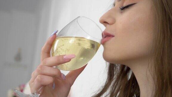 女孩喝香槟或葡萄酒与珍珠发光一个女人拿着一杯酒精饮料