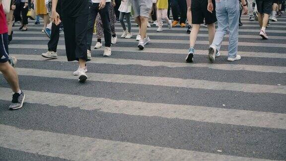 繁忙的人们在人行横道上缓慢移动的斑马线在高峰时间