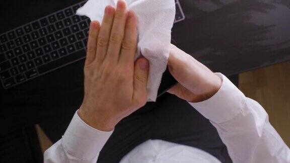 一男子用消毒湿纸巾擦拭智能手机