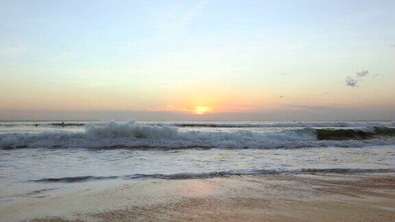 在热带海滩上与破浪宁静的日落