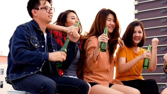 一群亚洲年轻人在屋顶上开啤酒瓶派对