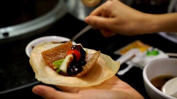 女人在中国菜北京烤鸭上滚