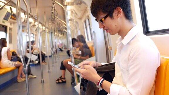 一名年轻人在火车上使用智能手机