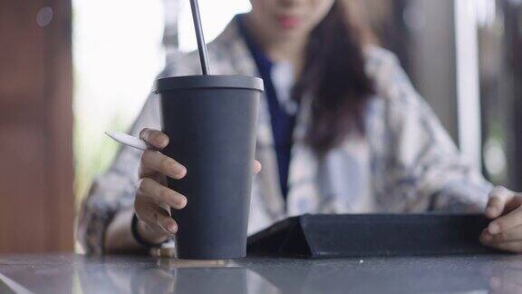 低角度拍摄的年轻亚洲女人喝从旅行杯