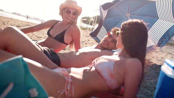 年轻的朋友们在夏岛度假在海滩上晒太阳