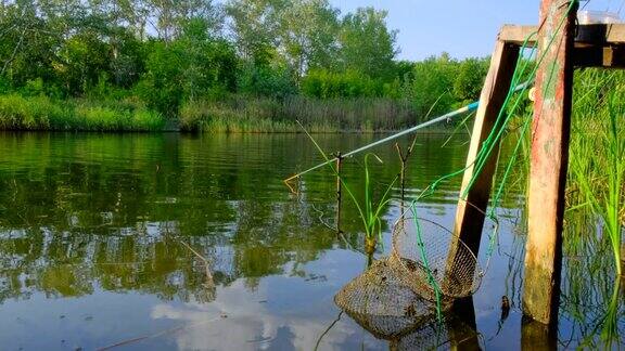 夏天河里有钓竿和浮子有浮子和笼子的垂钓钓具自然背景