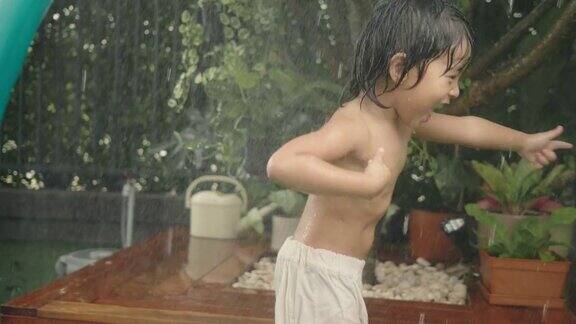 亚洲婴儿在自家前院笑着玩水