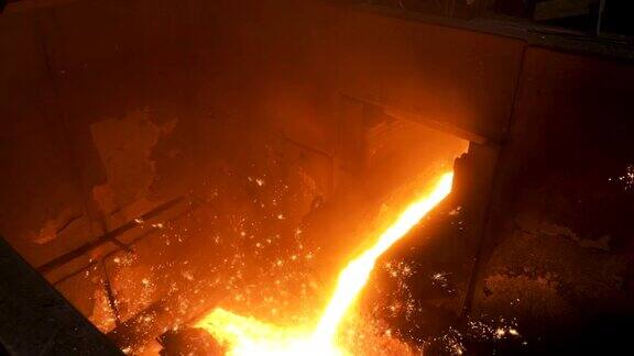 近距离观察铸造时从钢包中浇注的金属资料片冶炼金属铸件冶金生产的热车间是工厂的一个
