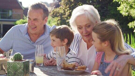 祖父母和孙辈享受户外夏日酒吧午餐