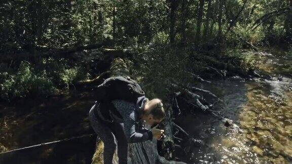 游客在森林河拍摄风景木桥倒树一名白人女性拍摄了漂亮的魔术女孩用相机拍照