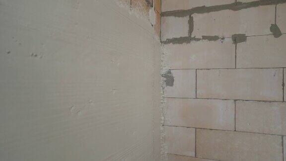 建筑工人用泥铲抹墙用抹刀调准后在墙上抹上新灰泥刚贴满墙