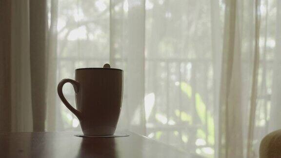 用咖啡杯吹窗帘