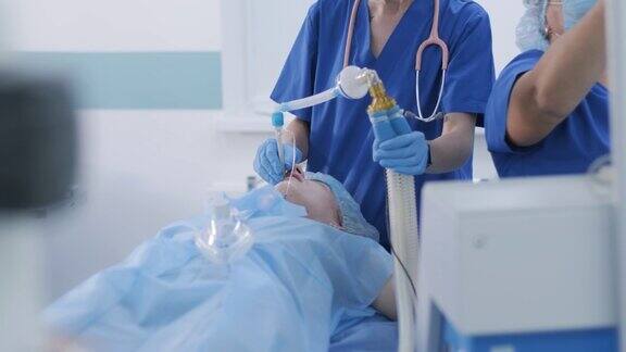 麻醉师和医疗队准备女患者手术将患者麻醉调节氧气面罩气管插管手术麻醉
