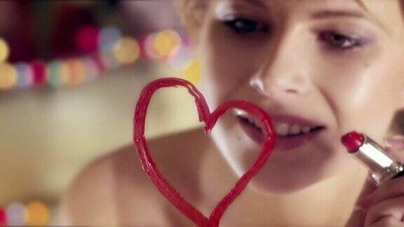 年轻女子用红唇在镜子上画心