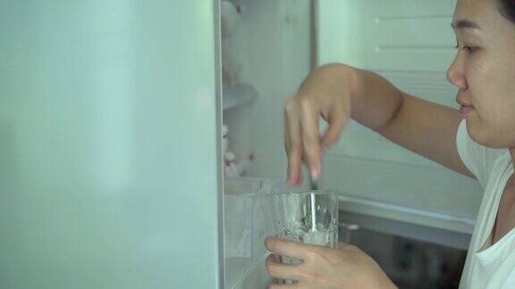 一个女人从冰箱里取出一块冰块