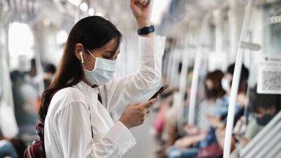 一个亚洲女人在火车上用手机