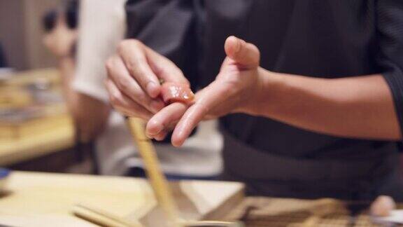 日式omagase餐厅的厨师用筷子烹饪并把鱼腥酱金枪鱼生鱼片放在日式料理中