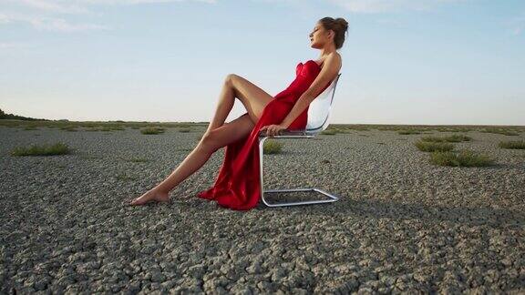 神奇的年轻女子坐在沙漠的椅子上