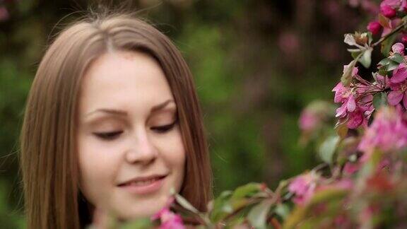 美丽的年轻女子在鲜花盛开的花园里