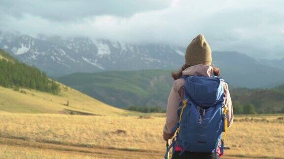 女人徒步旅行在山上徒步旅行女人旅行者背包上美丽的夏季风景