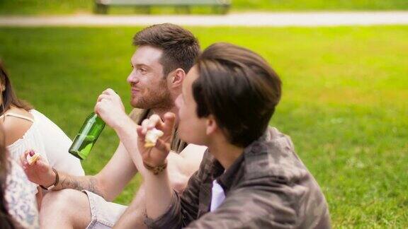 朋友们在野餐时喝着啤酒吃着三明治