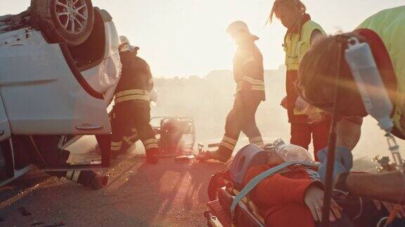 在车祸现场:医护人员拯救了一个躺在担架上的乘客的生命救援人员进入翻车车辆救出其他被困车辆的受害者
