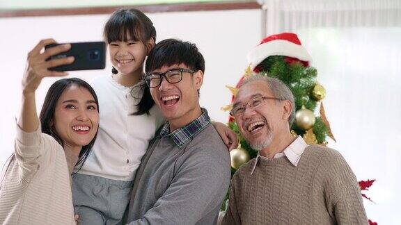 4K超高清手持多代亚洲幸福家庭与圣诞树一起自拍装饰后