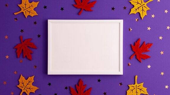 定格动画的黄色和红色毡秋天树叶星星形状和木制画框的紫色背景与复制空间万圣节的恐怖节日和秋天