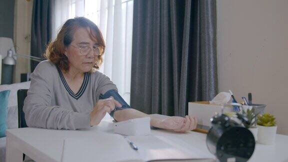 一位老年妇女在家测量自己的血压