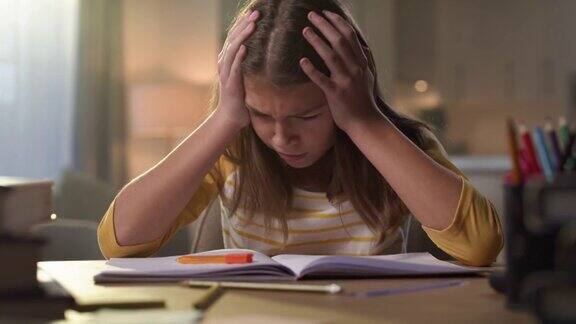 4k视频记录了一个小女孩独自坐在家里做作业时感到压力