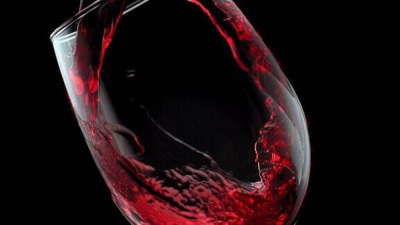 用慢动作将红酒倒入黑色背景的玻璃杯中