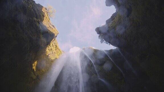 从阳光照耀的岩石上倾泻而下的瀑布