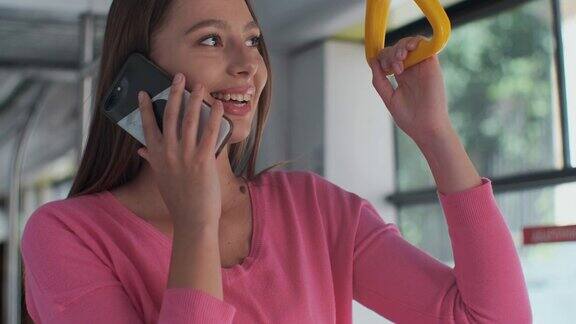一个年轻女子站在现代有轨电车里使用智能手机的特写