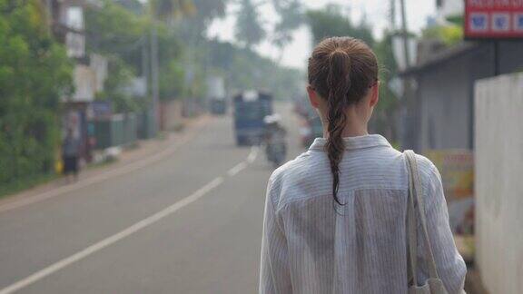 女游客走在热带自然的街道上