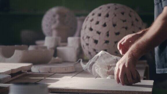 不知名的陶艺家在桌子上准备粘土
